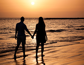 Couple walking along beach at Camp