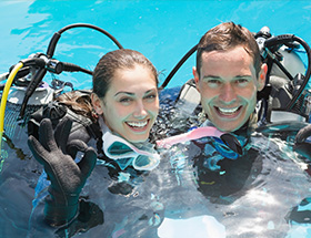 Happy man and woman trying scuba diving